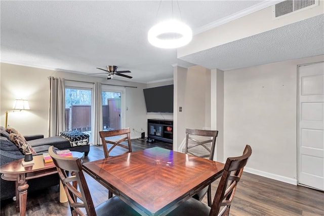 dining space featuring dark wood-style floors, ornamental molding, visible vents, and baseboards