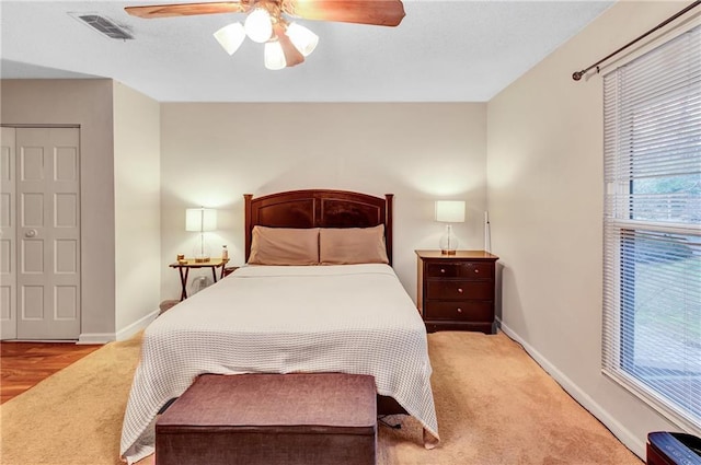 bedroom with a ceiling fan, carpet flooring, visible vents, and baseboards