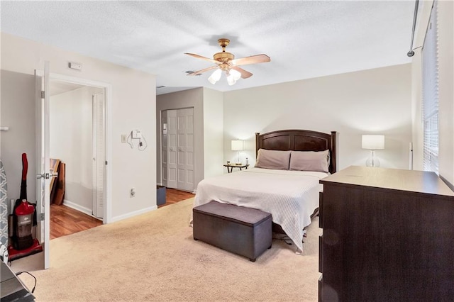 bedroom with carpet floors, a closet, a ceiling fan, a textured ceiling, and baseboards