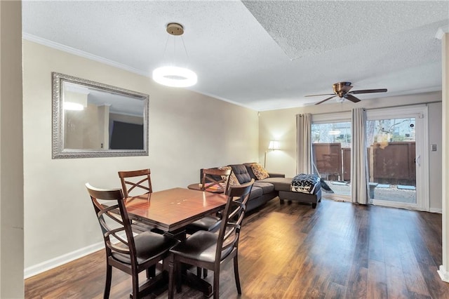 dining area featuring dark wood-style floors, ornamental molding, a textured ceiling, and baseboards