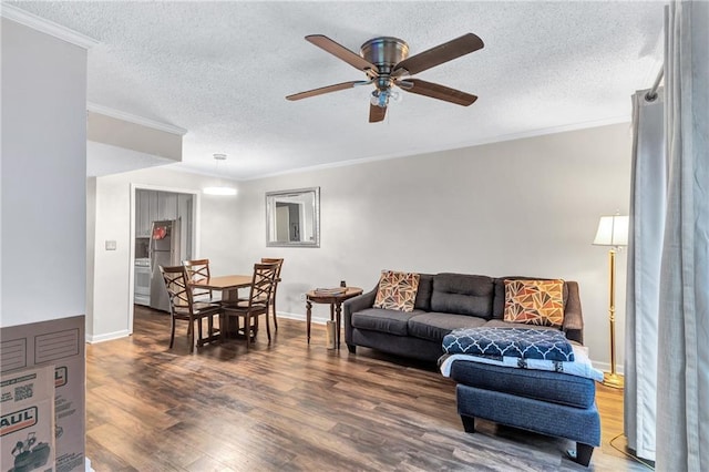 living room with a textured ceiling, ornamental molding, and wood finished floors