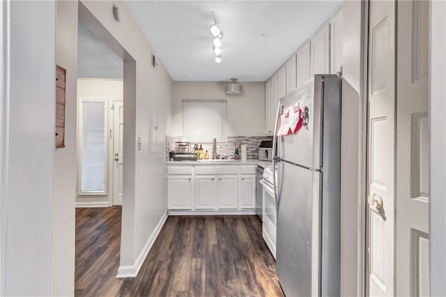 kitchen with dark wood-style flooring, white gas stove, light countertops, freestanding refrigerator, and a sink