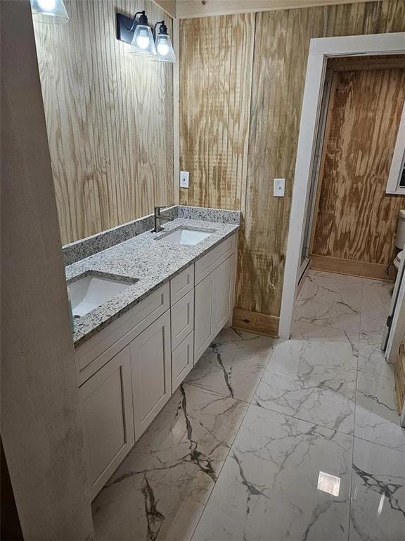 bathroom featuring wood walls and vanity