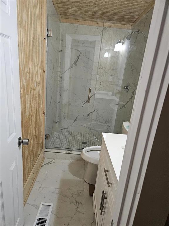 bathroom with vanity, a shower with shower door, and toilet