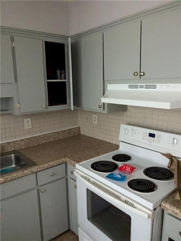 kitchen with dark countertops, electric range, gray cabinetry, backsplash, and under cabinet range hood