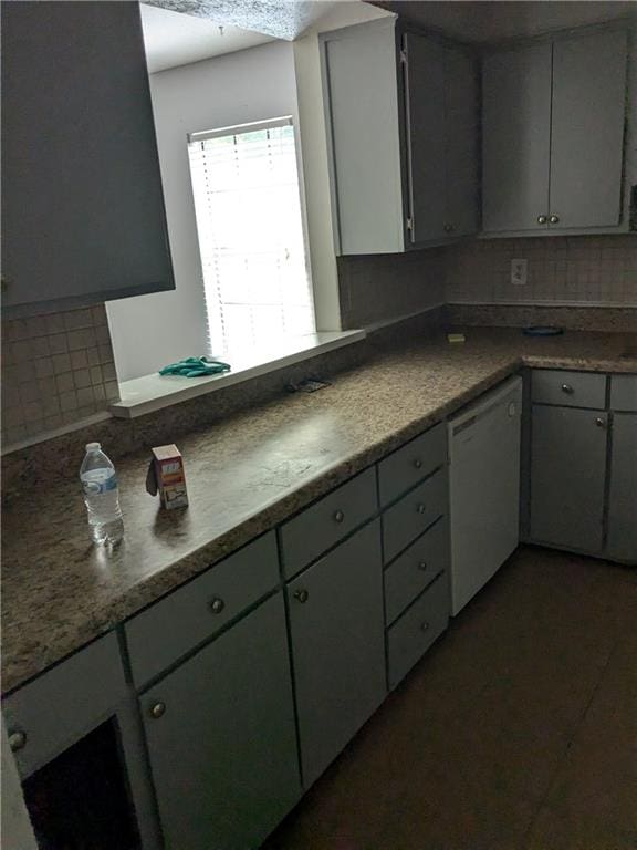 kitchen with gray cabinets, dishwasher, and decorative backsplash