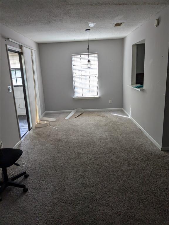 spare room featuring carpet and a textured ceiling