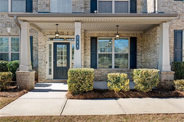 property entrance with brick siding and covered porch