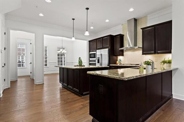 unfurnished living room with dark hardwood / wood-style flooring, ornamental molding, and ceiling fan with notable chandelier