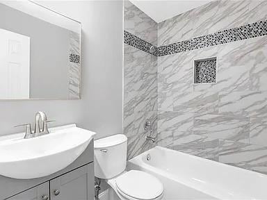full bath featuring toilet, bathing tub / shower combination, and vanity