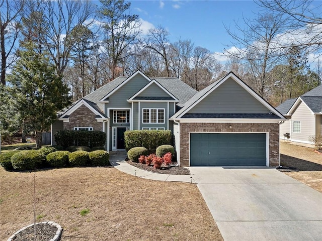 view of front of house with a garage, driveway, a shingled roof, and brick siding