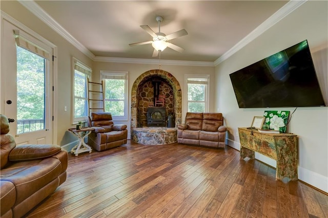 living room featuring hardwood / wood-style floors, ceiling fan, plenty of natural light, and a wood stove