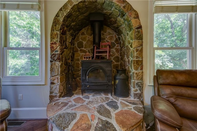 interior space featuring plenty of natural light, a wood stove, and wood-type flooring