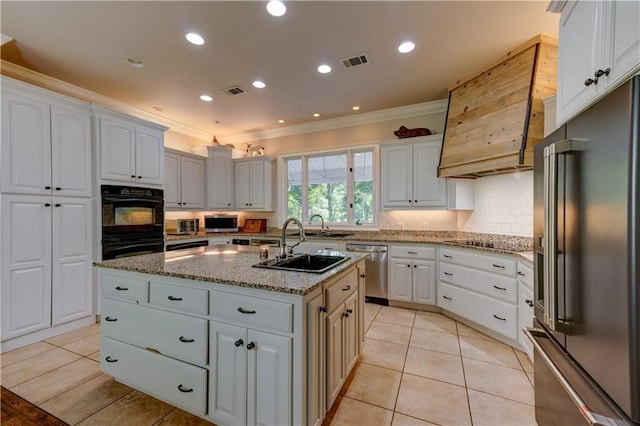 kitchen featuring black appliances, light stone counters, an island with sink, crown molding, and white cabinets