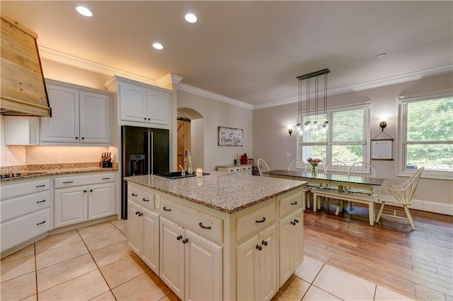 kitchen featuring white cabinetry, sink, light hardwood / wood-style flooring, a center island, and pendant lighting