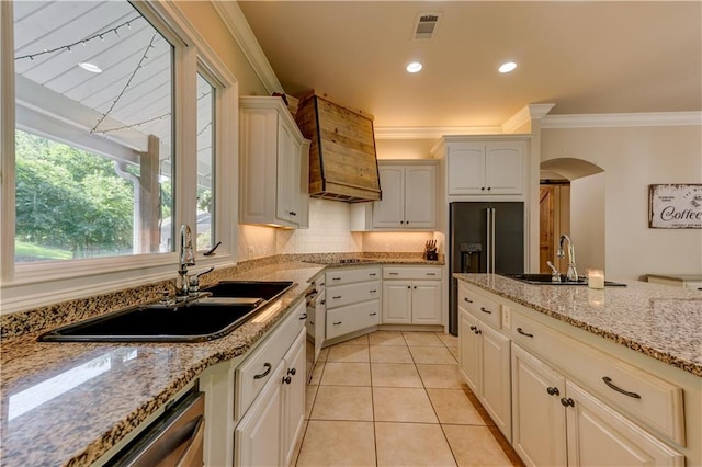 kitchen featuring light stone countertops, white cabinetry, sink, and crown molding