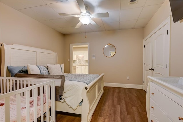 bedroom featuring a paneled ceiling, dark wood-type flooring, ceiling fan, and sink