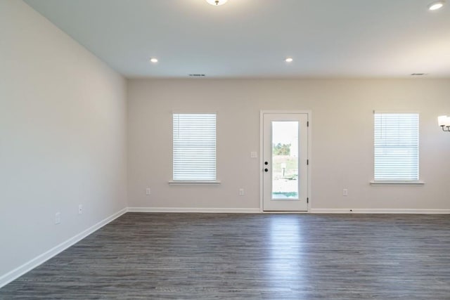 empty room with recessed lighting, dark wood-type flooring, and baseboards