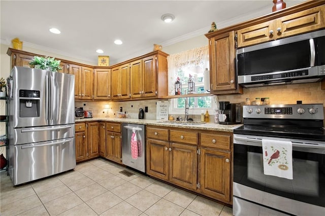 103 Mims Dr, Calhoun, GA 30701 - kitchen featuring appliances with stainless steel finishes, a sink, brown cabinets, ornamental molding, and backsplash