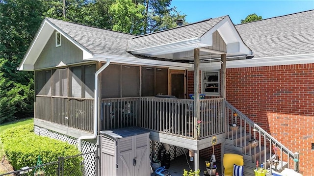 103 Mims Dr, Calhoun, GA 30701 - rear view of house featuring roof with shingles, brick siding, and a sunroom