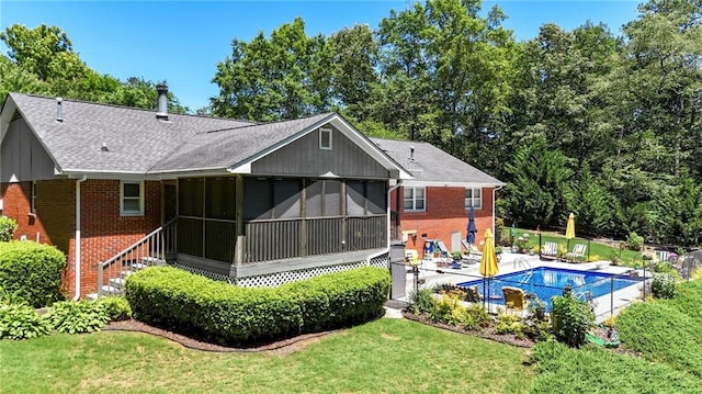 103 Mims Dr, Calhoun, GA 30701 - rear view of property featuring brick siding, a sunroom, roof with shingles, a yard, and a patio