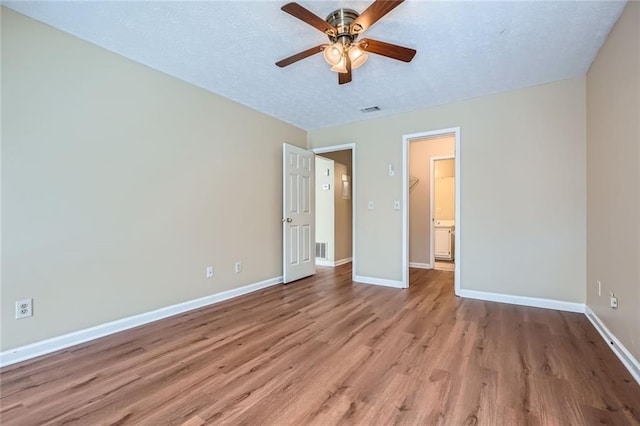 unfurnished bedroom featuring visible vents, baseboards, light wood finished floors, and a textured ceiling