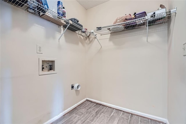 washroom featuring wood finish floors, electric dryer hookup, baseboards, hookup for a washing machine, and laundry area