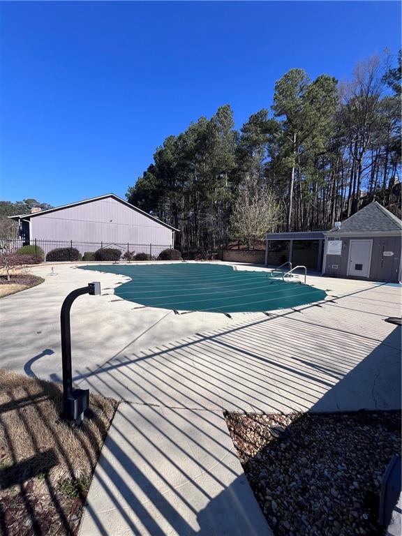 pool with a patio and fence