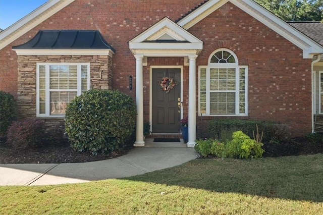 view of exterior entry featuring a yard