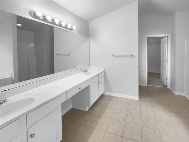 bathroom with vaulted ceiling, tile patterned floors, and vanity