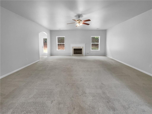 unfurnished living room featuring light carpet and ceiling fan