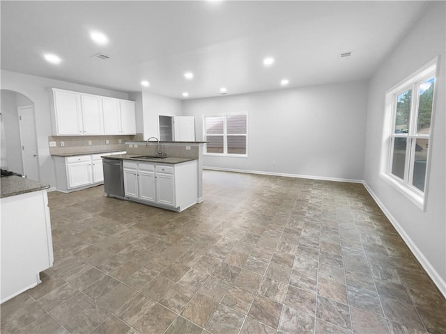 kitchen with sink, stainless steel dishwasher, an island with sink, and white cabinets