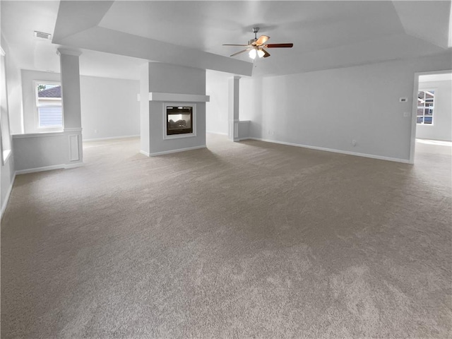 unfurnished living room featuring a multi sided fireplace, lofted ceiling, carpet flooring, and ceiling fan