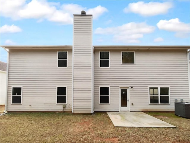 rear view of property featuring cooling unit, a lawn, and a patio