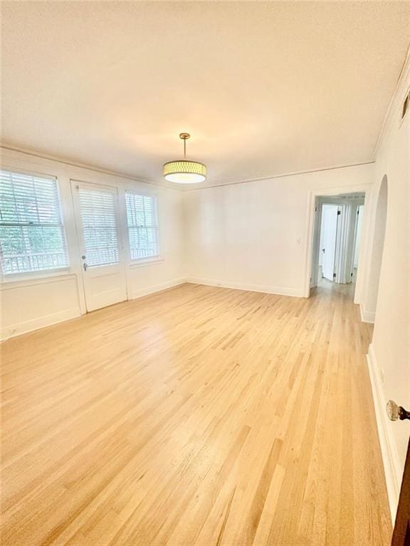 2230 Peachtree Rd NW Unit A4, Atlanta, GA 30309 - empty room featuring light wood-type flooring, baseboards, crown molding, and arched walkways