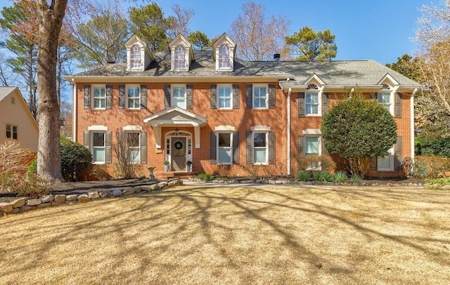 view of front of home with a front yard and brick siding