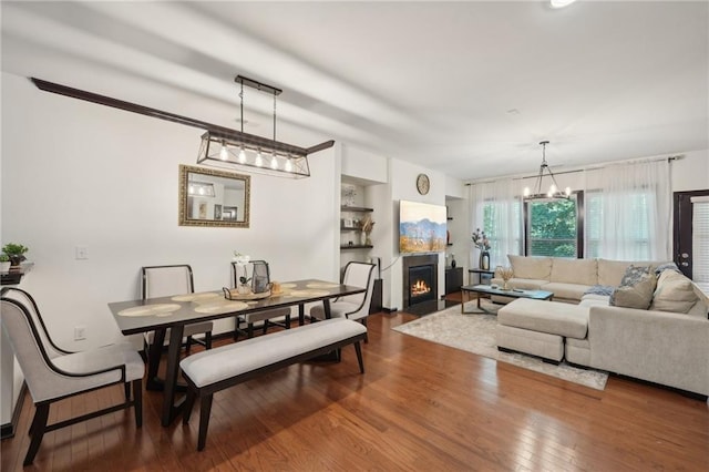 4430 Cedar Bridge Walk, Suwanee, GA 30024 - dining space with a fireplace with flush hearth, a chandelier, and wood finished floors