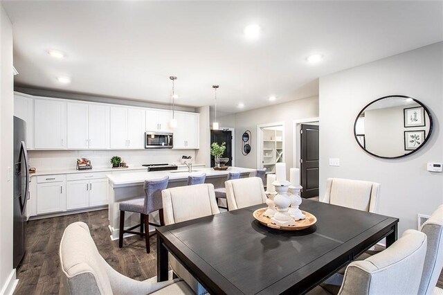 dining area with dark hardwood / wood-style flooring and sink