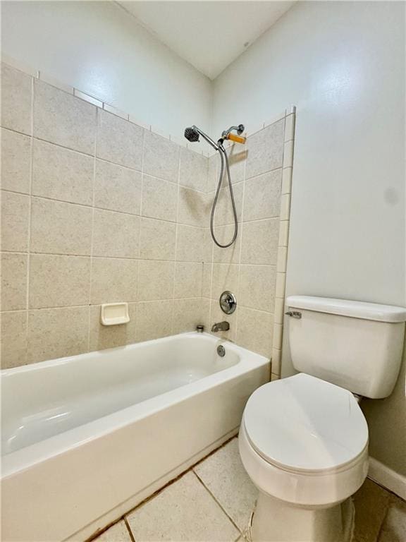 bathroom with tile patterned flooring, toilet, and tiled shower / bath