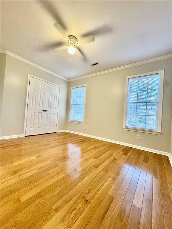 unfurnished bedroom featuring hardwood / wood-style floors, multiple windows, and ceiling fan