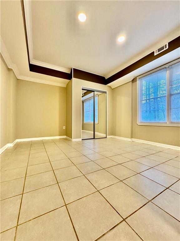 tiled spare room with ornamental molding