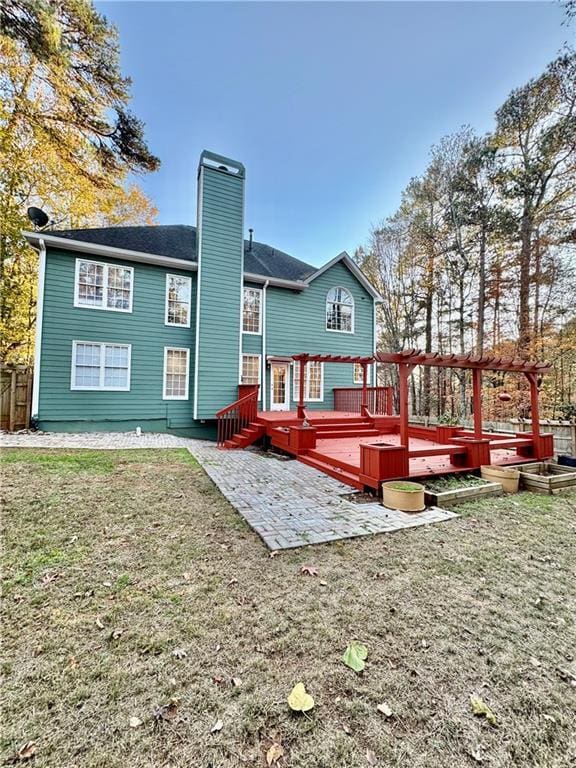 back of house featuring a lawn, a patio area, a deck, and a pergola