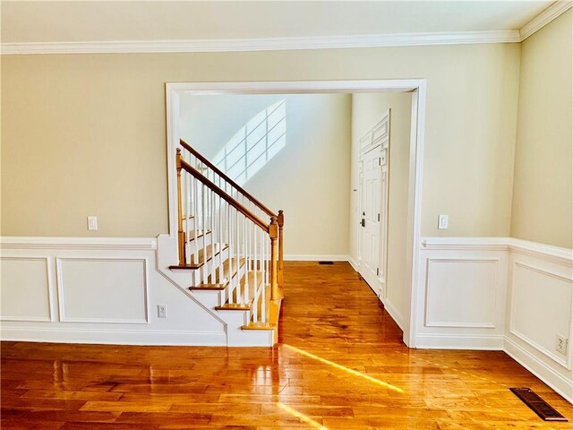 spare room featuring hardwood / wood-style flooring, a notable chandelier, and ornamental molding