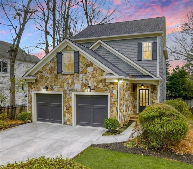 view of front facade with stone siding, driveway, and fence