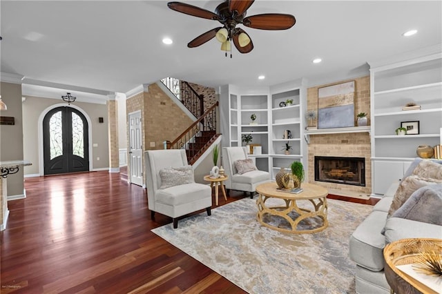2990 Hearthstone Dr, Cumming, GA 30041 - living room with french doors, wood finished floors, a brick fireplace, a ceiling fan, and stairs