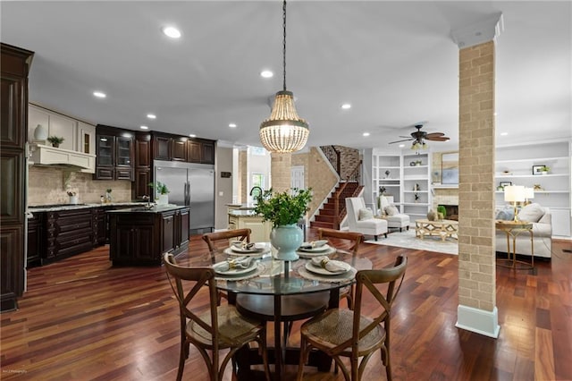2990 Hearthstone Dr, Cumming, GA 30041 - dining room featuring a ceiling fan, dark wood finished floors, ornate columns, recessed lighting, and a large fireplace