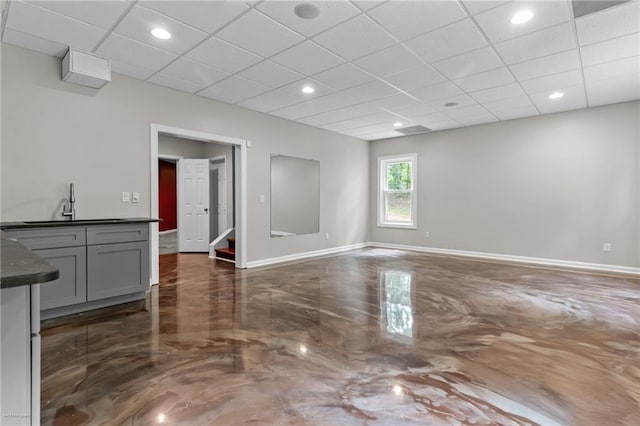 2990 Hearthstone Dr, Cumming, GA 30041 - unfurnished living room featuring baseboards, a paneled ceiling, stairway, a sink, and recessed lighting