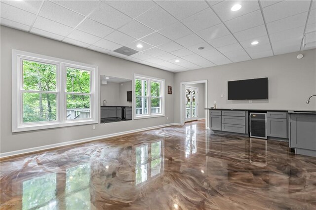 2990 Hearthstone Dr, Cumming, GA 30041 - unfurnished living room featuring beverage cooler, marble tiled flooring, a sink, baseboards, and a paneled ceiling