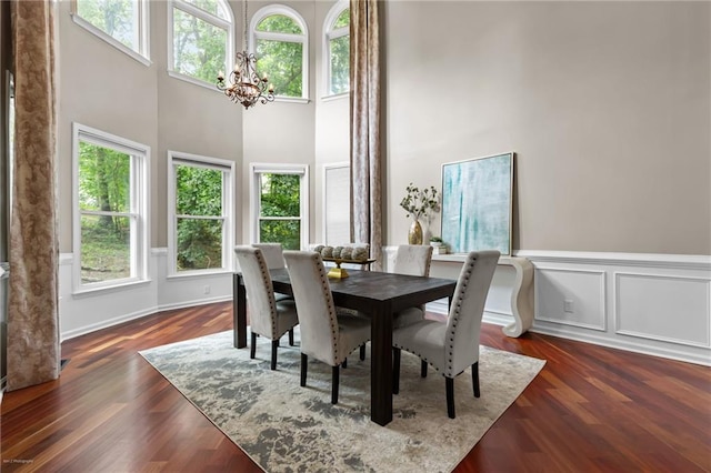 2990 Hearthstone Dr, Cumming, GA 30041 - dining area with a chandelier, a high ceiling, wainscoting, and dark wood-type flooring