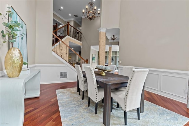 2990 Hearthstone Dr, Cumming, GA 30041 - dining room featuring a chandelier, stairway, wood finished floors, a wainscoted wall, and ornamental molding